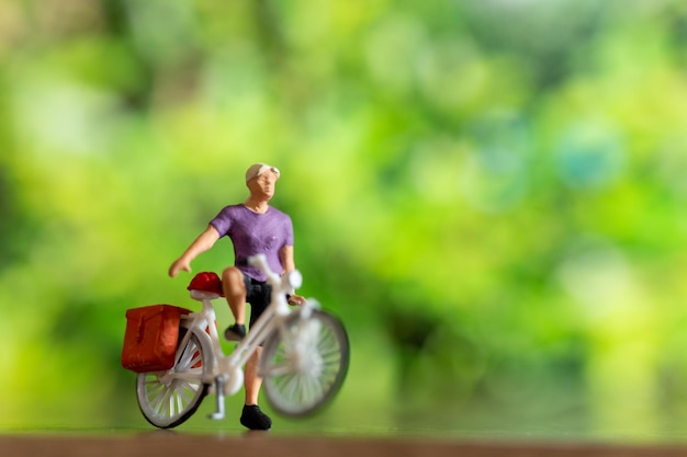 Persone in miniatura in piedi con la bici Giornata mondiale della bicicletta concetto