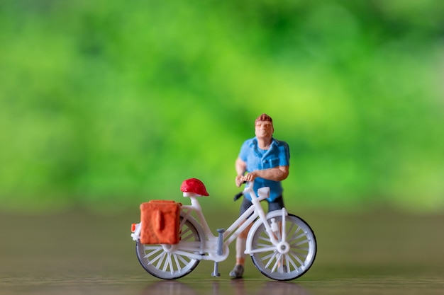 Persone in miniatura in piedi con la bici Giornata mondiale della bicicletta concetto