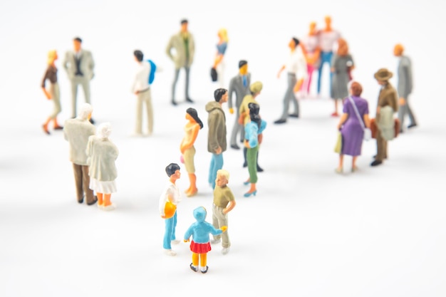 Persone in miniatura persone diverse comunicano tra loro su uno sfondo bianco