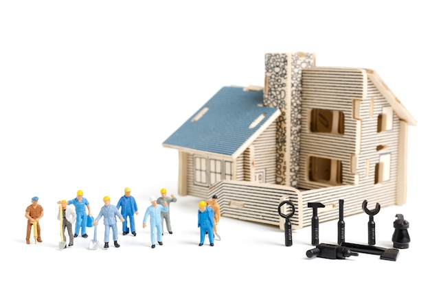 Persone in miniatura: squadra di lavoratore con strumenti per forniture casa di riparazione su sfondo bianco