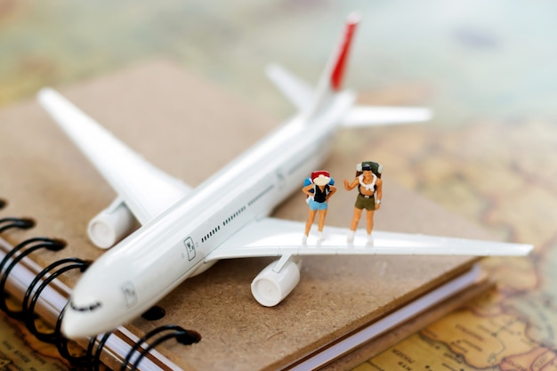 Persone in miniatura: viaggiare con uno zaino viaggiando in aereo.