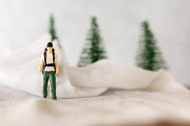 Persone in miniatura Viaggiatore con zaino e sacco a pelo in inverno