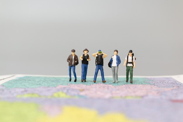 Persone in miniatura Zaino in spalla che cammina sulla mappa Concetti di viaggio e avventura.