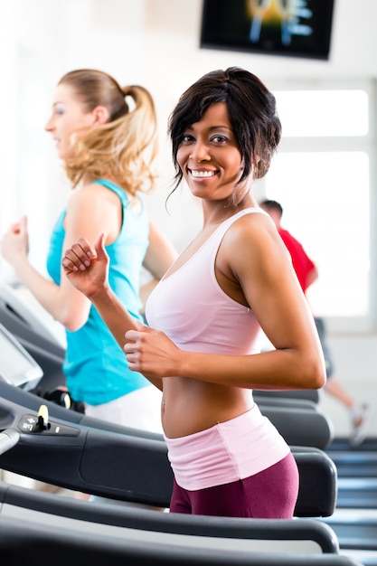 Persone in palestra sportiva sul tapis roulant in esecuzione