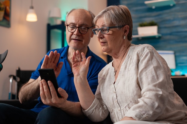 Persone in pensione su smartphone videochiamate insieme