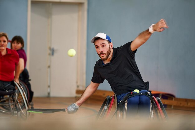 Persone in sedia a rotelle che giocano a tennis sul campo Tennis in sedia a rotelle per disabili