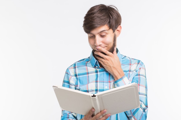 Persone, lettura e concetto di educazione - giovane che legge un libro su sfondo bianco