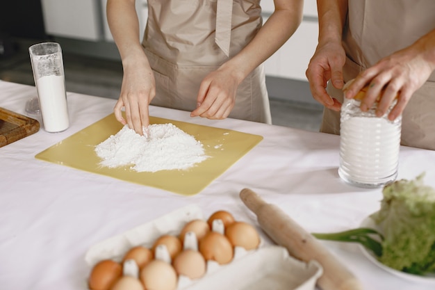 Persone mentre si preparano gli gnocchi. Persone asiatiche in grembiuli.