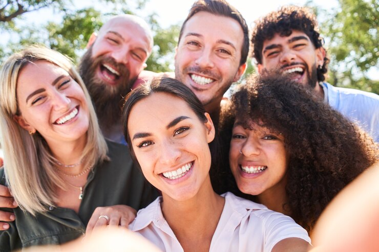 Persone multirazziali che si fanno un selfie all'aperto, un concetto di stile di vita felice con giovani sorridenti che si divertono.