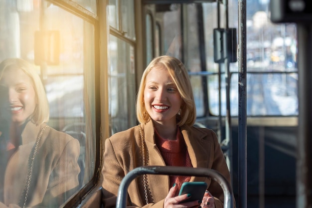 persone nei trasporti pubblici passeggeri donna passeggero che guarda lo schermo del suo smartphone