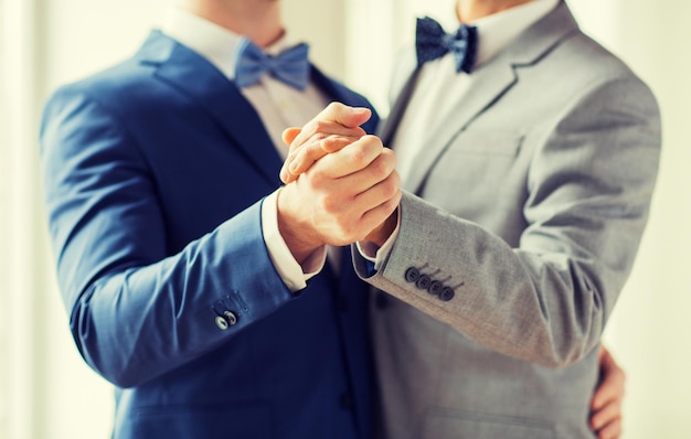 persone, omosessualità, matrimonio omosessuale e concetto di amore - primo piano di coppia gay maschio felice che si tiene per mano e balla sul matrimonio