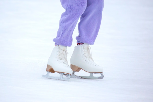 Persone pattinaggio su ghiaccio su una pista di pattinaggio. hobby e tempo libero. sport invernali