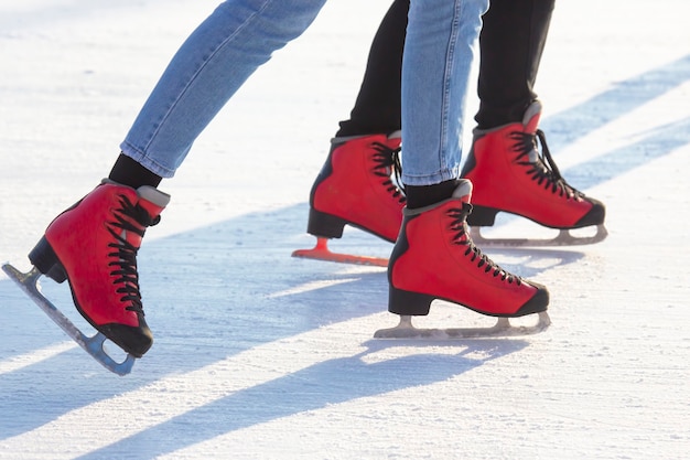 Persone pattinaggio su ghiaccio su una pista di pattinaggio. hobby e tempo libero. sport invernali