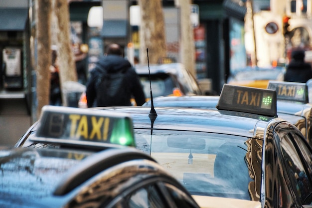 Persone per strada in città ai taxi in primo piano