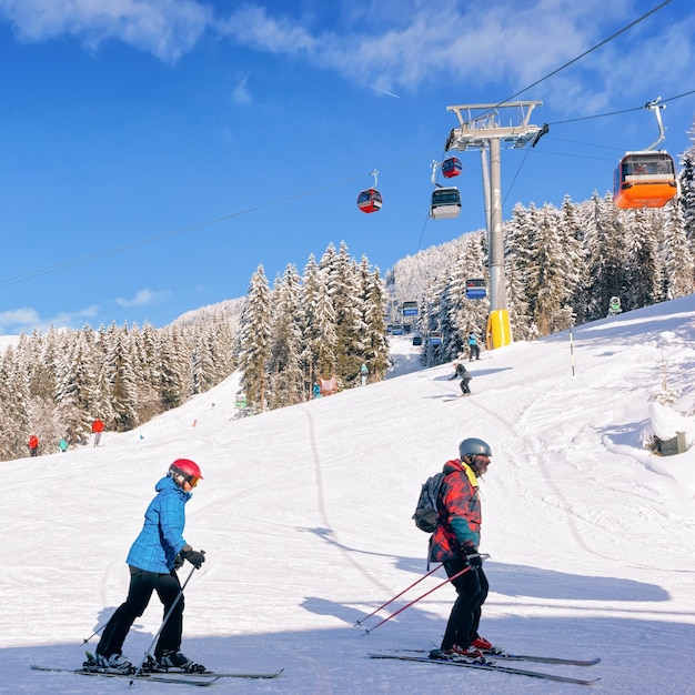 Persone Sciatori che sciano nella stazione sciistica Zillertal Arena in Tirolo a Mayrhofen in Austria nelle Alpi invernali. Sciare nelle montagne alpine con neve bianca e cielo blu. Funivie nelle piste innevate austriache.