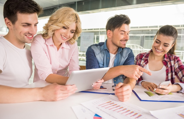 Persone sedute in ufficio e lavorano insieme.