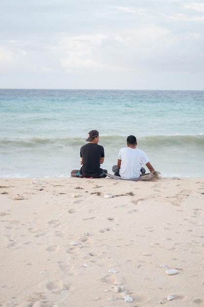 persone sedute sulla spiaggia nel pomeriggio