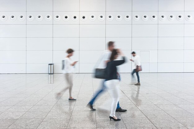 Persone sfocate che camminano nel corridoio nella hall