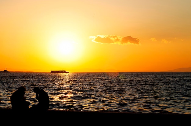 Persone Silhouette e il mare al tramonto nella luce pomeridiana