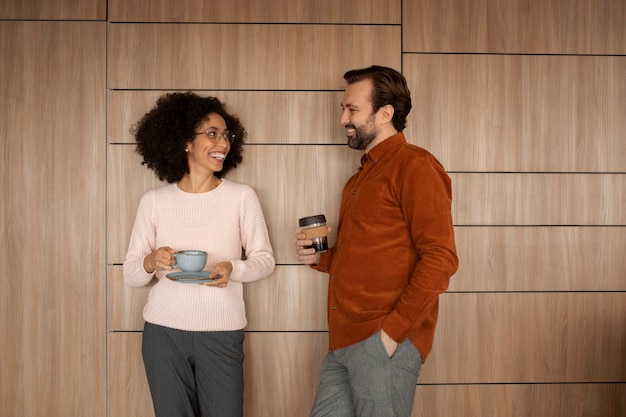 Persone sorridenti con tazze di caffè di medie dimensioni