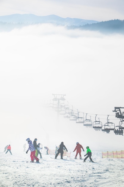 Persone sulla pista da sci che imparano a guidare le famiglie resort invernale