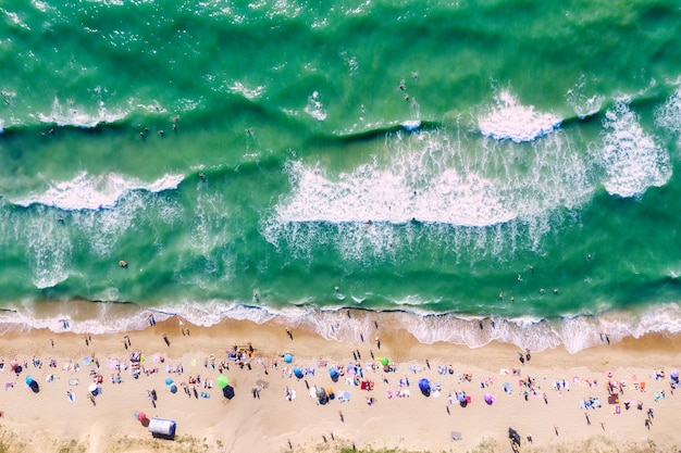 Persone sulla spiaggia e persone che nuotano nel mare