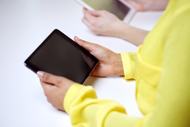 persone, tecnologia e concetto di internet - primo piano delle mani femminili con tablet pc a tavola