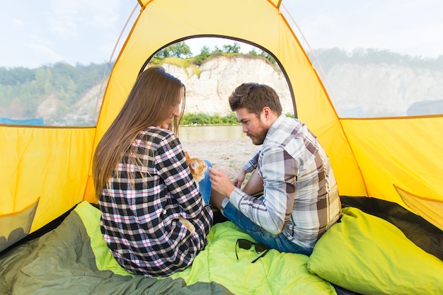 Persone, turismo e concetto di natura - Coppia carina seduta con un gatto in tenda gialla.