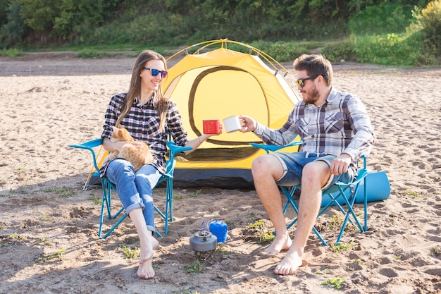 Persone, turismo estivo e concetto di natura - giovane coppia che beve tè vicino alla tenda.