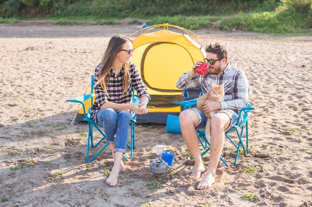 Persone, turismo estivo e concetto di natura - giovane coppia che beve tè vicino alla tenda.