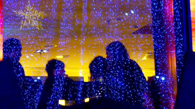 Foto persone viste attraverso un vetro illuminato