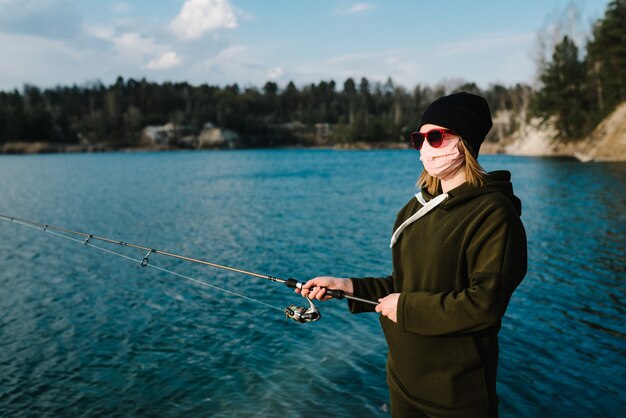 Pesca del luccio, del pesce persico, della carpa sullo stagno. Auto-isolamento in natura, protezione, coronavirus.