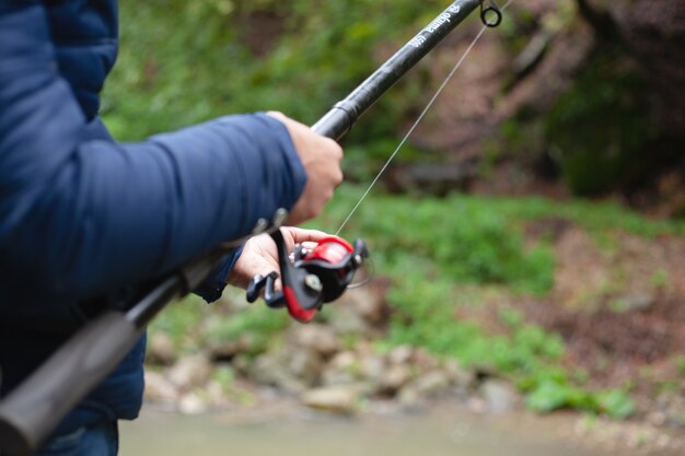 pescatore che pesca in riva al fiume in autunno