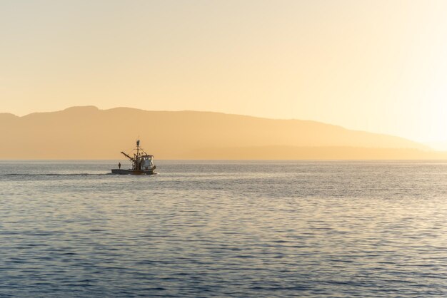 Pescatore in barca a vela la sera