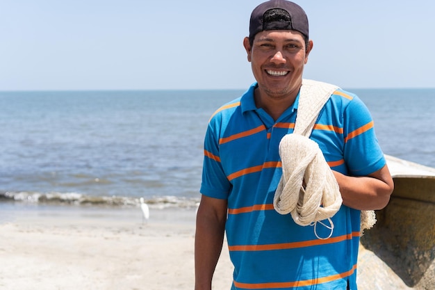 Pescatore in piedi sulla spiaggia sorridente ritratto