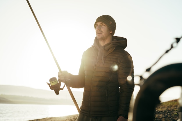 Pescatore maschio che pesca nel lago all'alba