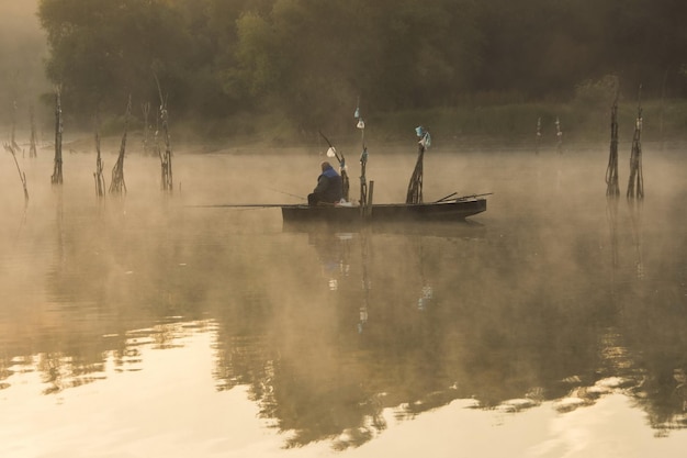 Pescatore nella nebbia mattutina