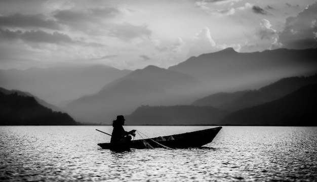 Pescatore su una barca in bianco e nero