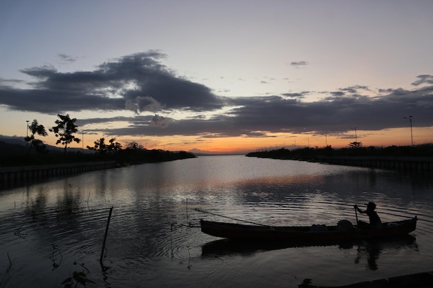 Pescatore sulla sua barca al tramonto. Barca dei pescatori al tramonto