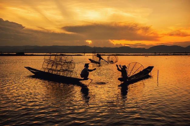 Pescatori birmani di Intha sul pesce di cattura della barca tradizionale nel lago Inle, Shan State, Myanmar