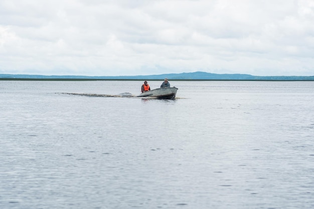 pescatori su una barca a motore attraversano un ampio lago