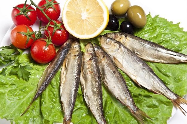 Pesce affumicato servito con pomodoro, finocchi e olive