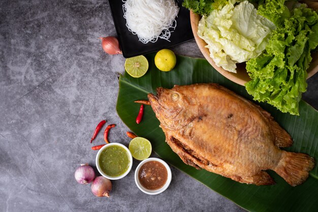 Pesce arrostito rustico sul tavolo da cucina, alimento tailandese tradizionale.