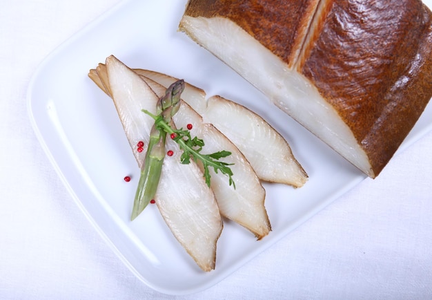 Pesce bianco fresco decorato con insalata e condimento. Avvicinamento