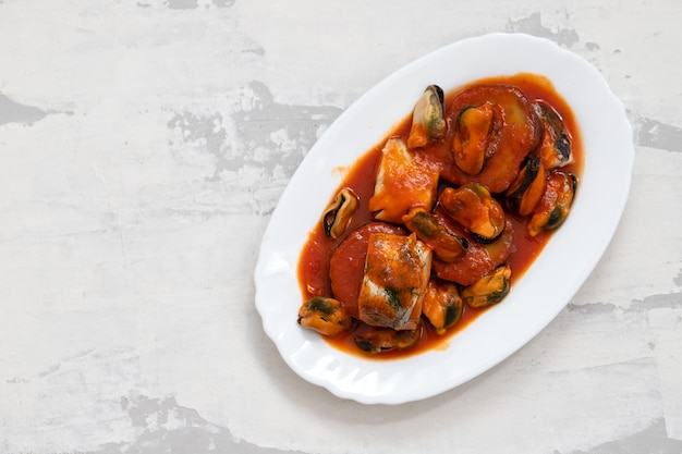 Pesce con frutti di mare e patate dolci sul piatto bianco