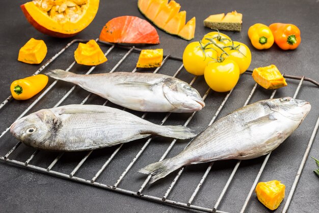 Pesce crudo con verdure colorate sulla griglia