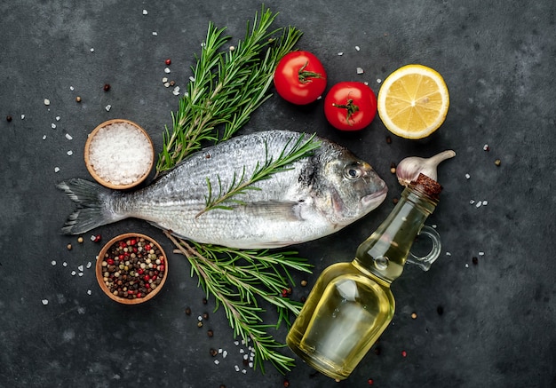 Pesce crudo di dorado con spezie e ingredienti pomodoro, razmorin, olio di semi di girasole, limone su uno sfondo di pietra