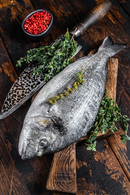 Pesce crudo di dorado su un tagliere con coltello