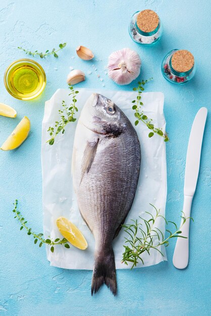 Pesce crudo Dorado con ingredienti da cucina Sfondo in pietra blu Vista dall'alto