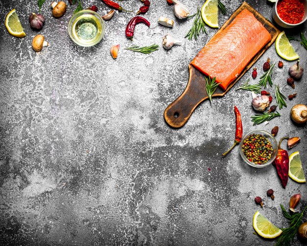 Pesce crudo. Filetto di salmone fresco con erbe e spezie sul tavolo rustico.